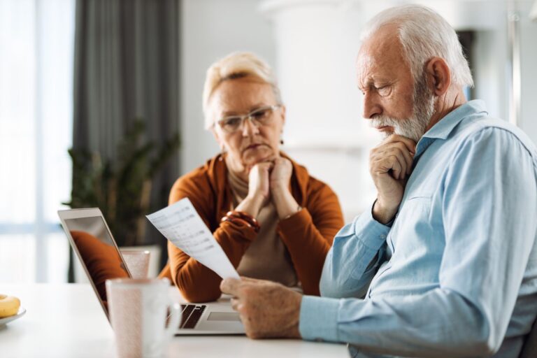 busy-senior-couple-in-casual-clothing-doing-paperw-2022-10-28-04-54-08-utc-scaled-e1668729570389