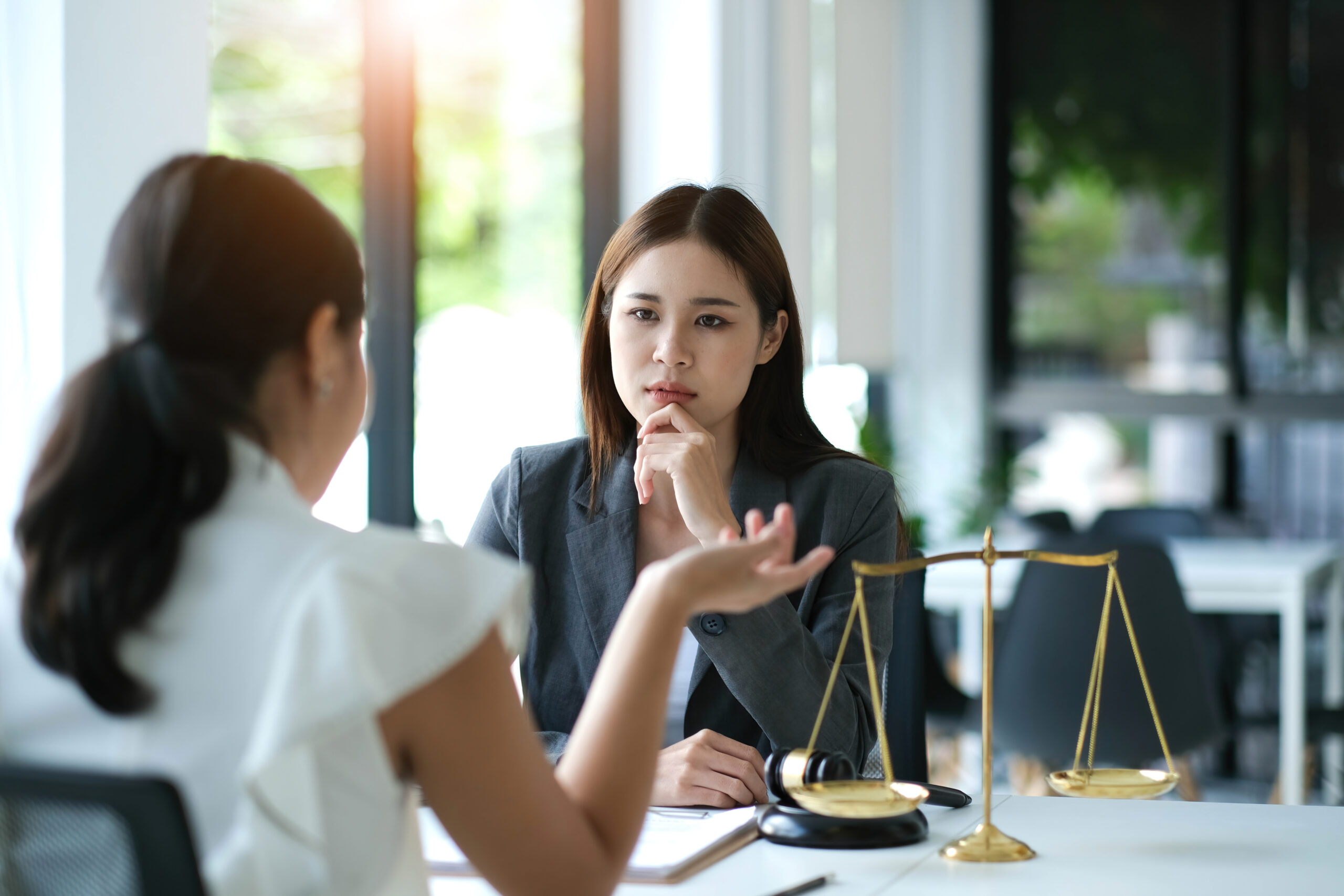 Business woman and lawyers discussing contract papers with brass