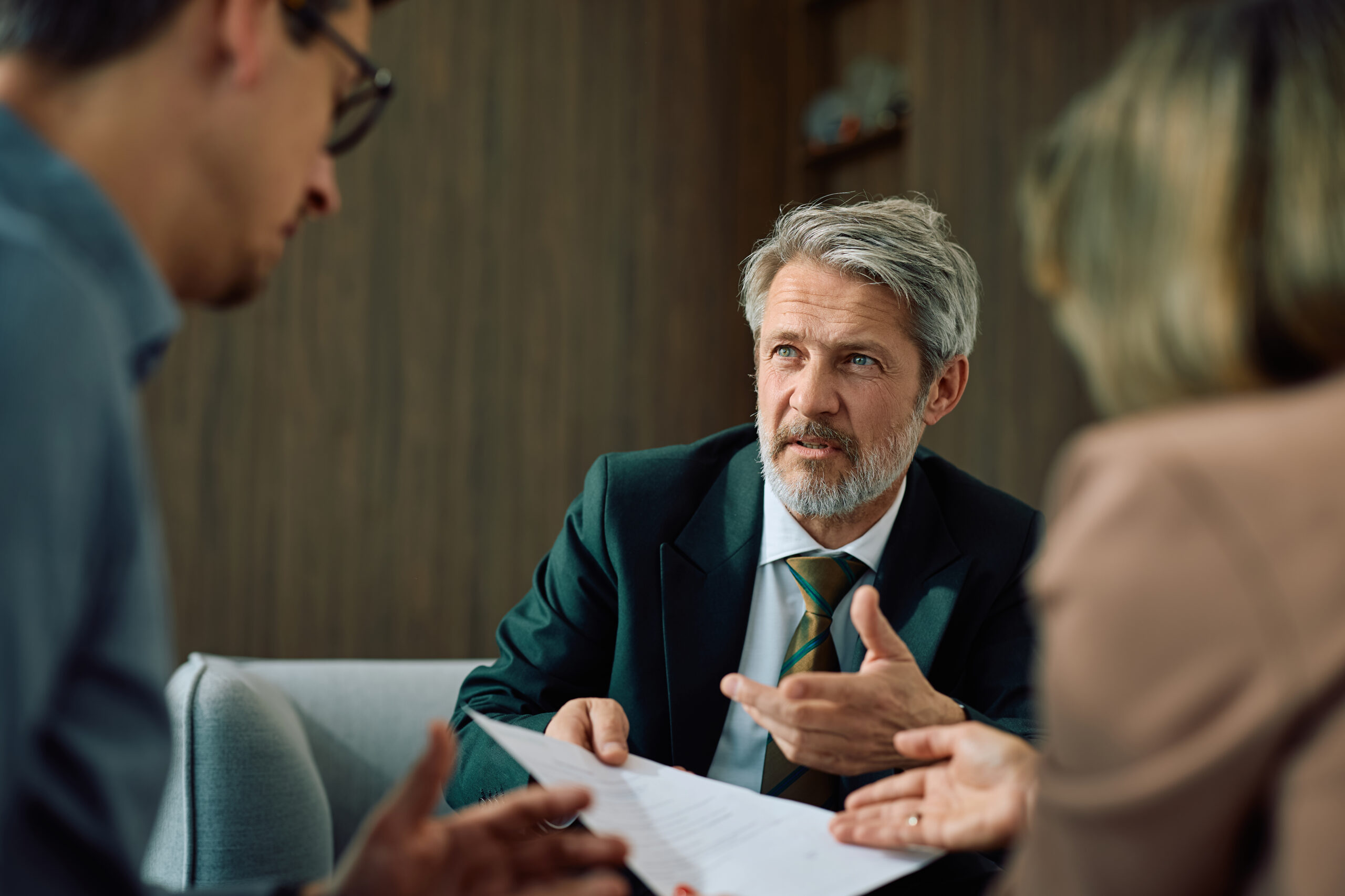 Mature insurance agent having a meeting with a couple in the office